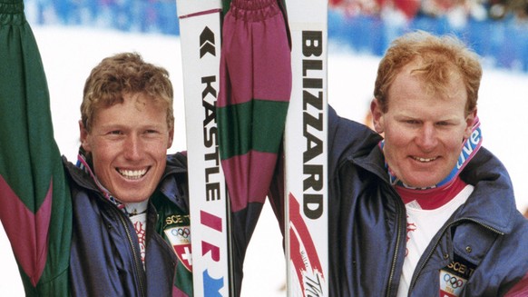 Die Schweizer Pirmin Zurbriggen, Mitte, Gold, Peter Mueller, rechts, Silber, und der Franzose Franck Piccard, links, Bronze, freuen sich im Ziel ueber ihren Erfolg in der Ski alpin Abfahrt der olympis ...