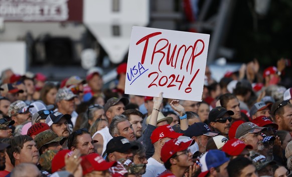 epa09424242 A supporter displays a placard as former US President Donald Trump participates in a rally sponsored by the Alabama Republican Party at the York Family Farms in Cullman, Alabama, USA, 21 A ...