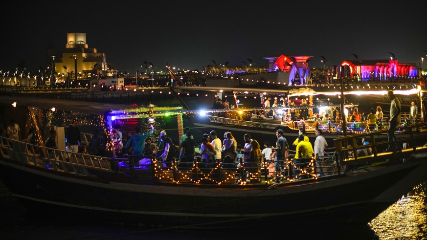 People onboard wooden boats for a sail at the Corniche sea promenade in Doha, Qatar, Friday, Nov. 18, 2022. (AP Photo/Francisco Seco)