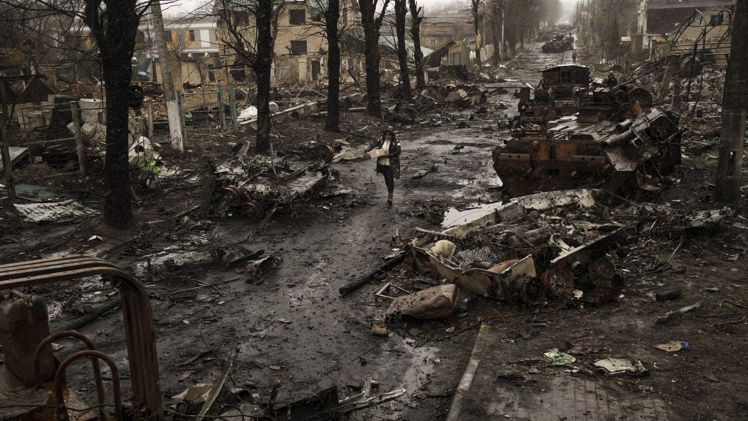 A woman walks amid destroyed Russian tanks in Bucha, on the outskirts of Kiev, Ukraine, April 3, 2022. The photo was part of a series of images by Associated Press photographers covering the 2…