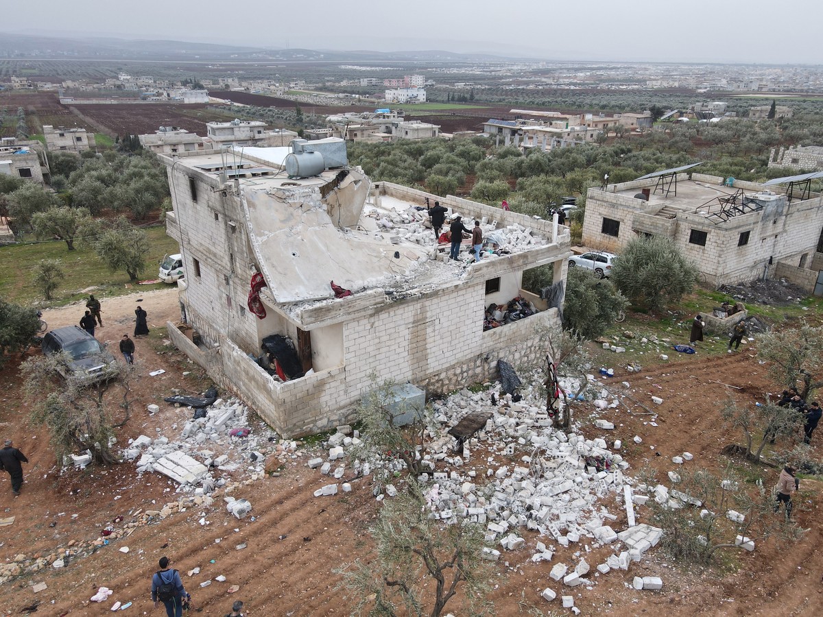 epaselect epa09724582 An aerial picture taken by a drone shows people inspecting a damaged building after an alleged counterterrorism operation by US Special forces in the early morning in Atma villag ...