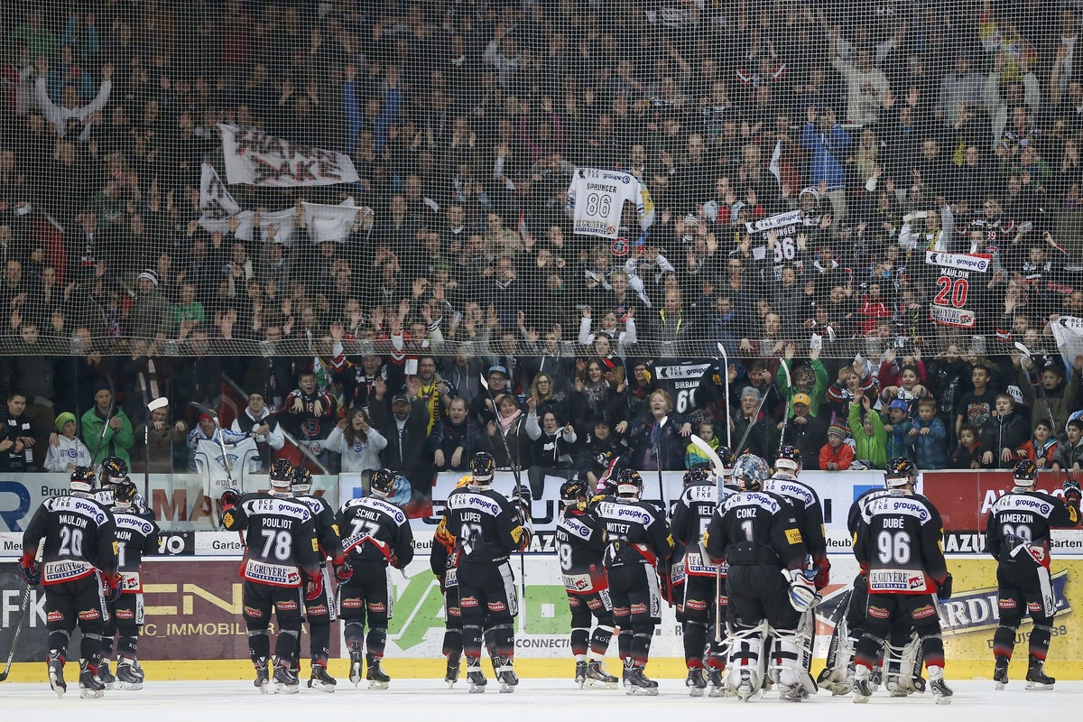 Fribourgs Spieler jubeln mit ihren Fans nach dem Sieg im dritten Playoff-Viertelfinalspiel der National League A zwischen dem HC Fribourg-Gotteron und dem HC Ambri-Piotta am Samstag, 15. Maerz 2014, i ...