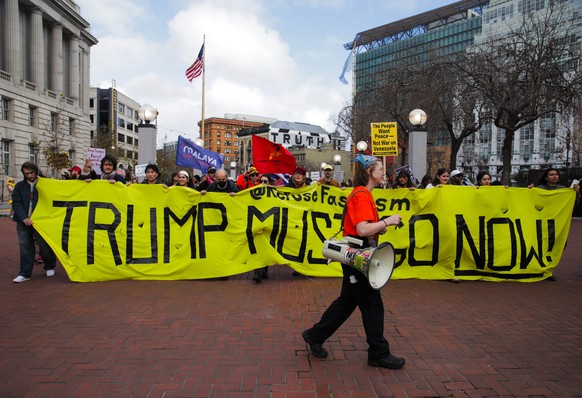 Protestors hold a banner stating "Trump Must Go Now" as they gather outside the UN Plaza during a demonstration against the U.S. bombing of Venezuela and seizure of Venezuelan President Nico ...