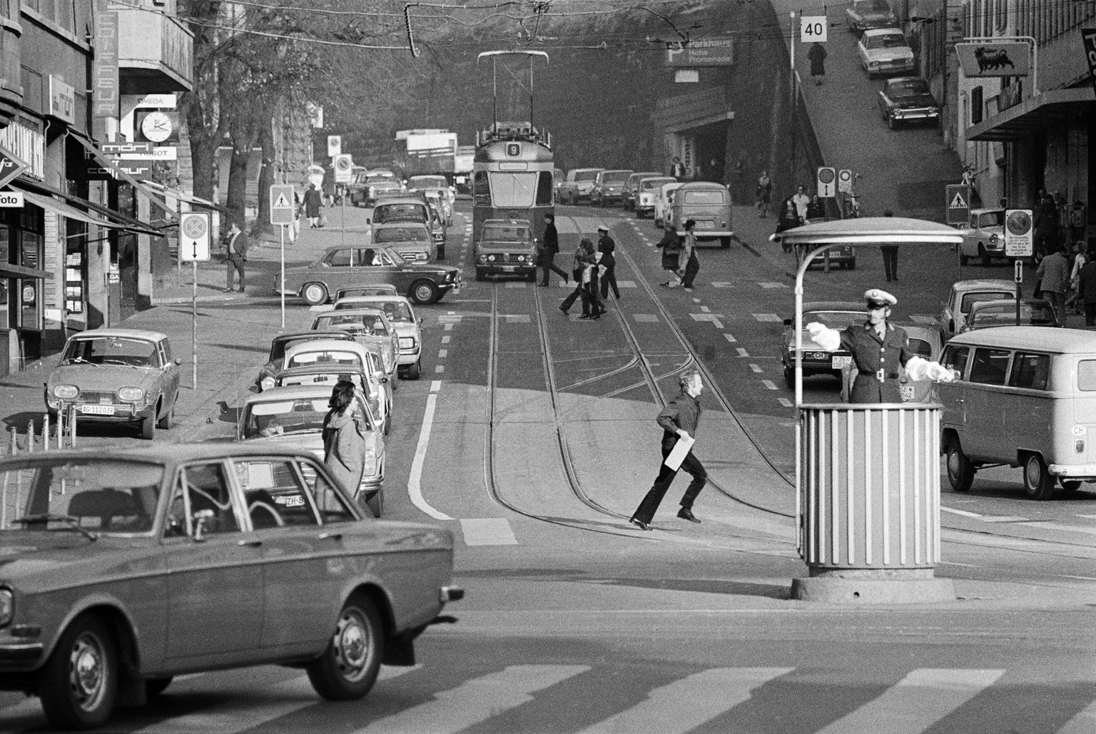 Ein Polizist regelt den Verkehr aus der Verkehrskanzel am Bellevue in Zürich, aufgenommen im November 1971.