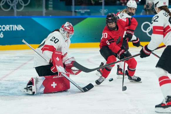 Canada's Blayre Turnbull attempts to score next to Switzerland's Andrea Braendli, left,during a semifinal match of women's ice hockey between the Canada and Switzerland at the 2026 Wint ...