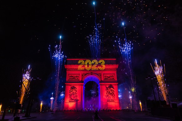 epa10384561 A light and fireworks show displayed on the Arc de Triomphe as revelers celebrate the new year 2023 on the Champs-Elysees avenue in Paris, France, 01 January 2023. EPA/CHRISTOPHE PETIT TES ...