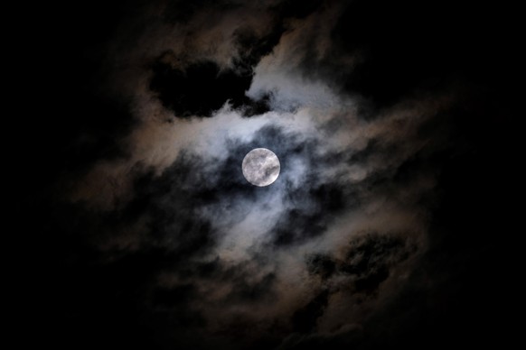 Der Vollmond am Nachthimmel hinter Wolken