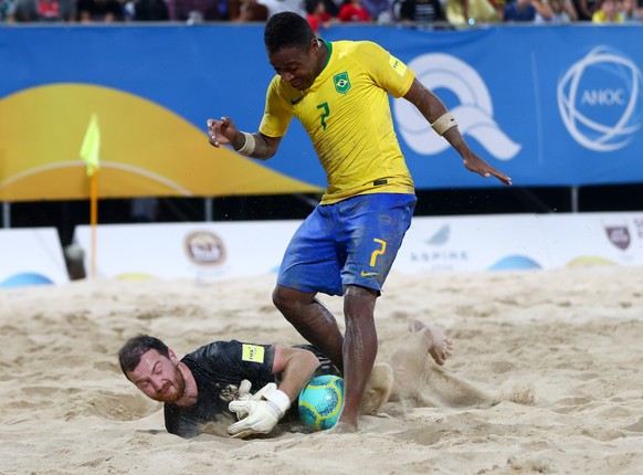 191017 - Doha, October.  Xinhua / Xinhua / Brazilian Bukina R competed with Ivan Ostrovsky of Russia during the men's beach soccer final between Brazil and Russia at the first-ever ANOC World Beach Games in Qatar...
