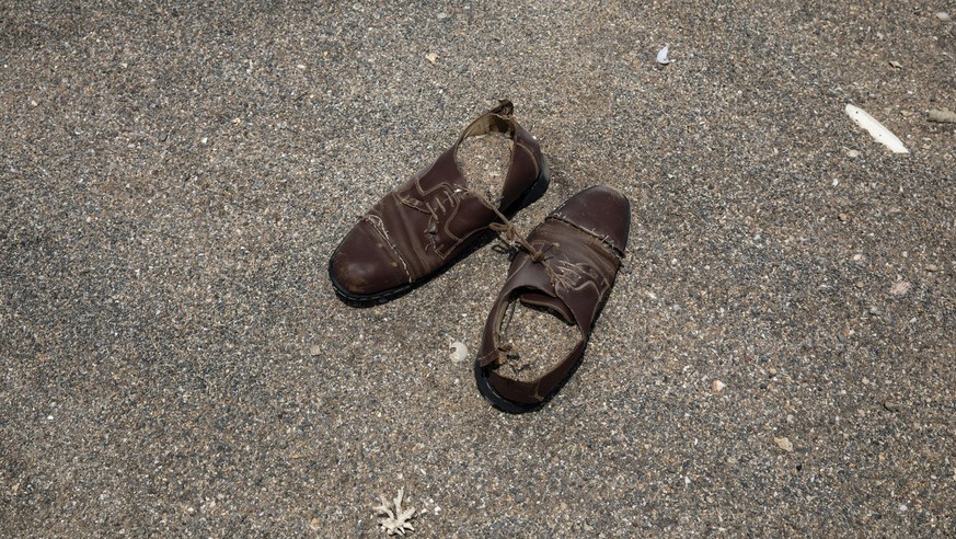 This July 15, 2019 photo, shows a pair of shoes belonging to a migrant left on the sand where African migrants gather at night to embark a boat in the uninhabited coast outside the town of Obock, the  ...