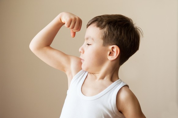 Kid boy child showing muscles fist strength training, Boy showing muscular biceps as arnold schwarzenegger model released