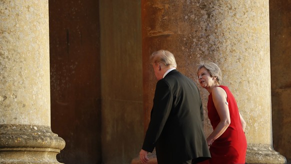 British Prime Minister Theresa May, right, talks with President Donald Trump, left, as they walk into Blenheim Palace, Oxfordshire, where May will host a dinner as part of Trump&#039;s visit to the Un ...