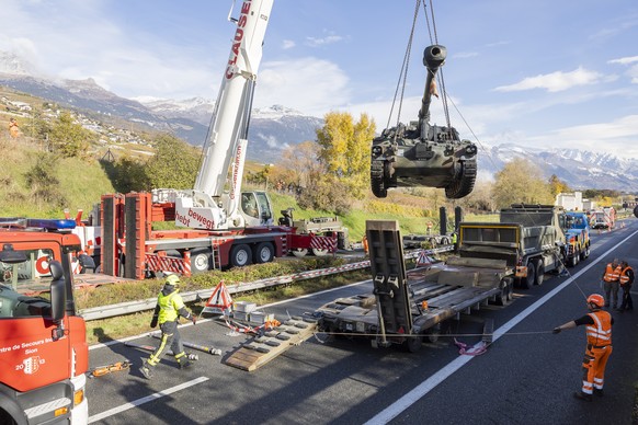 Une grue degage un camion de l?armee transportant un char blinde immobilises sur l?autoroute A9, entre Sion et Sierre suite a un accident entre deux camions de l&#039;armee ce mardi 12 novembre 2024 a ...