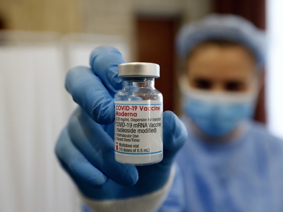 epa09538930 A Romanian volunteer nurse displays a Moderna vaccine dose to a patient at a Covid-19 Marathon Vaccination For Life center organized at Children Palace venue in Bucharest, Romania, 22 Octo ...