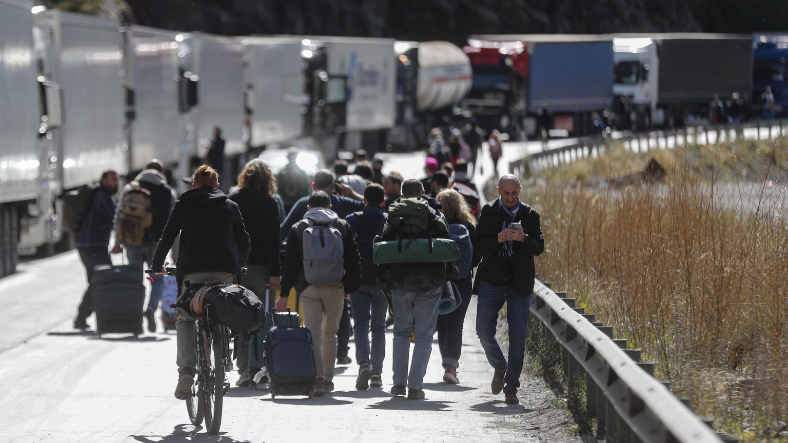 epa10364859 Russian men walk along the road with their luggage after passing through customs at the Georgia-Russia border checkpoint of Verkhnii Lars, Georgia, 27 September 2022. Thousands of Russian  ...