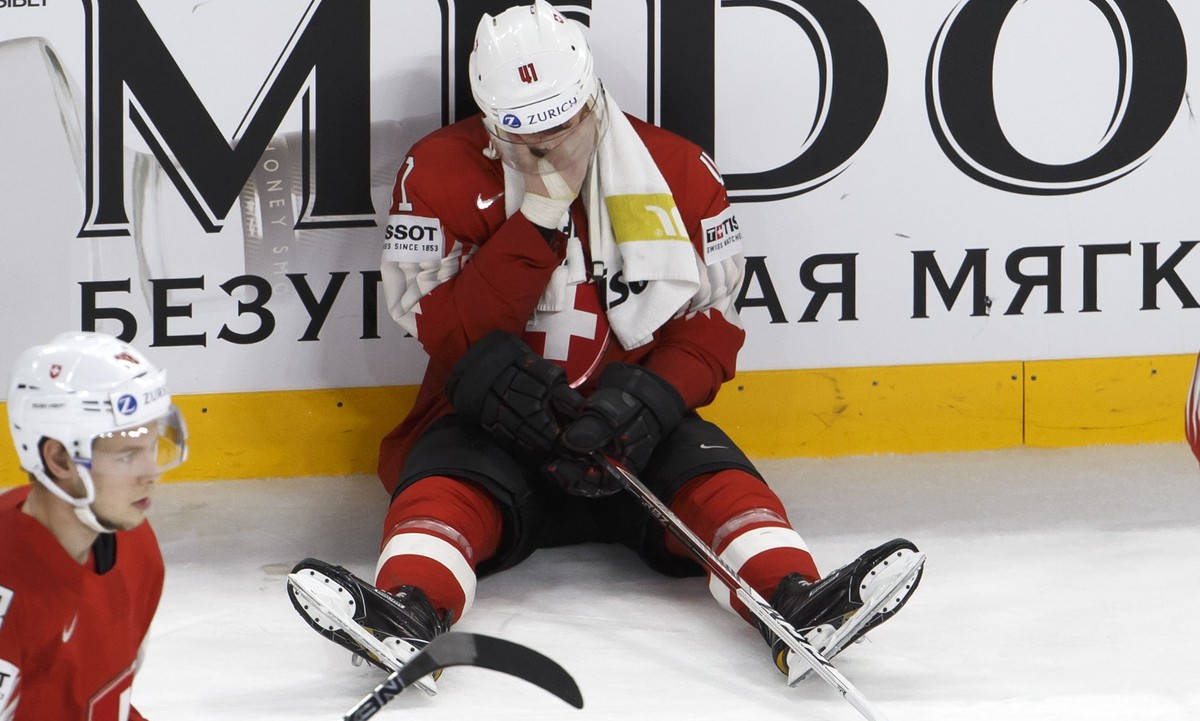epa06753351 Switzerland's players defender Lukas Frick, left, defender Mirco Mueller, centre, and goaltender Reto Berra, right, react after losing against team Sweden, during the overtime of the  ...