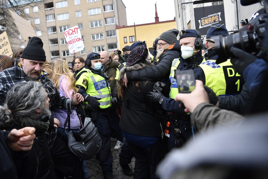 Anti-lockdown protesters face police as they demonstrate against coronavirus restrictions in Stockholm Saturday March 6, 2021. The protest was disbanded by police due to lack of permit for the public  ...
