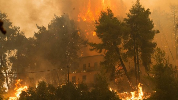 210809 -- EVIA, August 9, 2021 -- A house is seen in flames on the northern island of Evia, Greece, August 8, 2021. Wildfires continue to rage across Greece, especially on the island of Evia over the weekend, with thousands ...