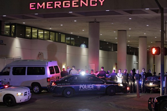 epa05414821 Dallas police officers and hospital staff form a line around the emergency entrance to Baylor Scott&amp;White Hospital as a police officer&#039;s body is taken from the facility in Dallas, ...