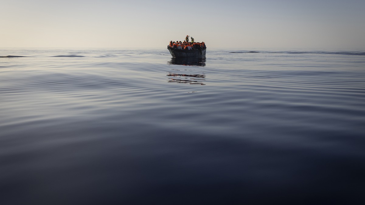 FILE - Migrants with life jackets provided by volunteers of the Ocean Viking, a migrant search and rescue ship run by NGOs SOS Mediterranee and the International Federation of Red Cross (IFCR), still  ...