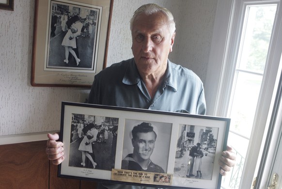 In this July 2, 2009, photo George Mendonsa poses for a photo in Middletown, R.I., holding a copy of the famous Alfred Eisenstadt photo of Mendonsa kissing a woman in a nurse&#039;s uniform in Times S ...