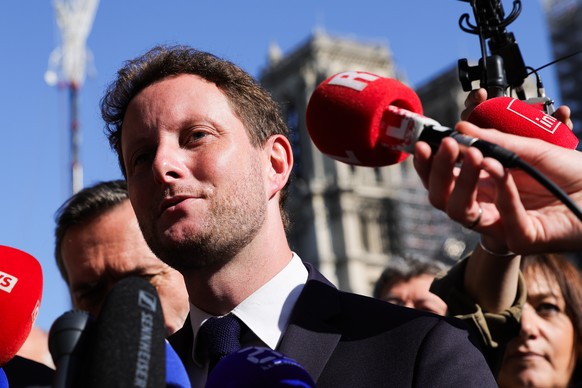 epa10739056 French Minister of Transport Clement Beaune speaks to the press before the arrival of the frameworks of Notre-Dame Cathedral in Paris, France, 11 July 2023. Since the fire which devastated ...