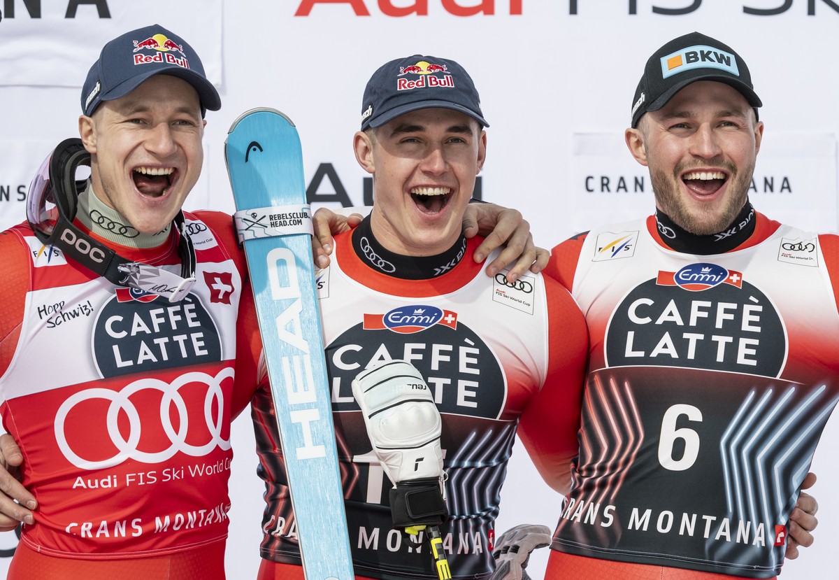 Winner Franjo von Allmen of Switzerland, center, second placed Marco Odermatt of Switzerland, left, and third placed Alexis Monney of Switzerland, right, celebrate on the podium after the men's D ...