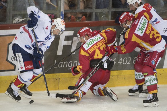 Tigers Antti Erkinjuntti, Mitte, und Benjamin Neukom, rechts, kaempfen um den Puck, gegen Lions Ronalds Kenins, links, waehrend dem Meisterschaftsspiel der National League, zwischen den SCL Tigers und ...