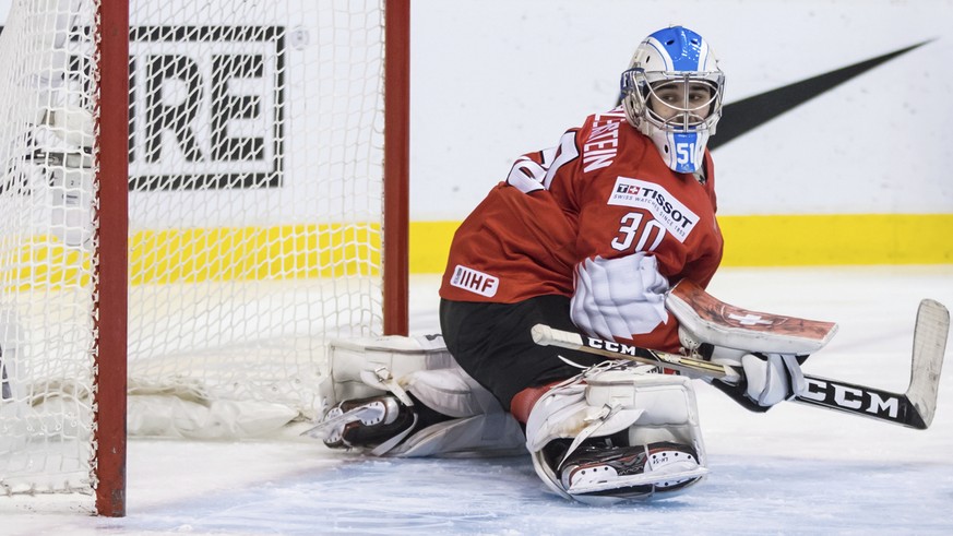 Switzerland goalie Luca Hollenstein looks at the puck in the net after allowing a goal to Finland&#039;s Jesse Ylonen during first-period IIHF world junior semifinal hockey action in Vancouver, Britis ...