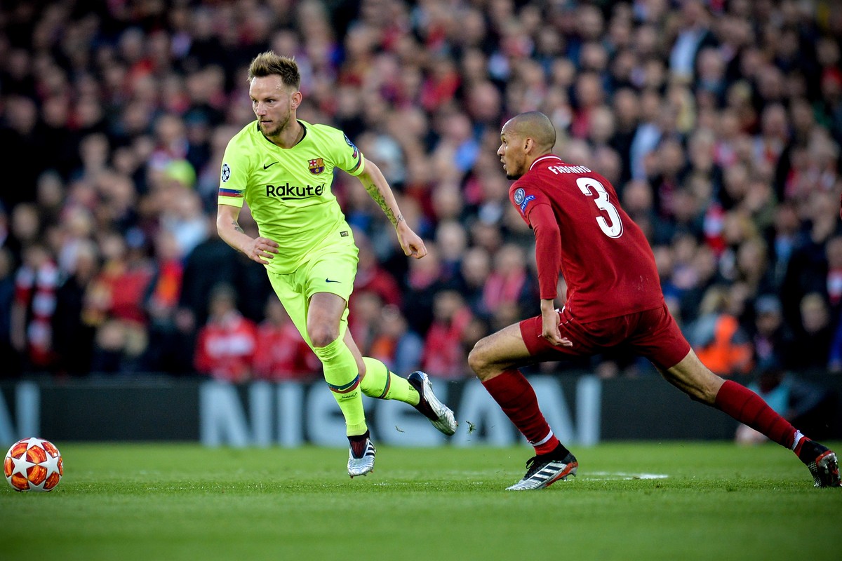 epa07554501 Barcelona's Ivan Rakitic (L) in action against Liverpool's Fabinho (R) during the UEFA Champions League semi final second leg soccer match between Liverpool FC and FC Barcelona a ...