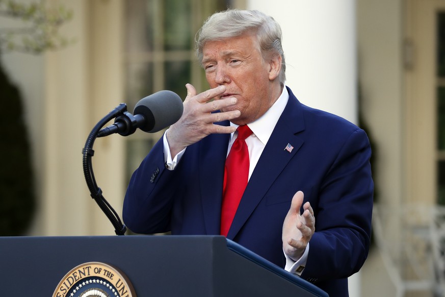 President Donald Trump holds his hand to his face as he talks about masks during a briefing about the coronavirus in the Rose Garden of the White House, Monday, March 30, 2020, in Washington. (AP Phot ...