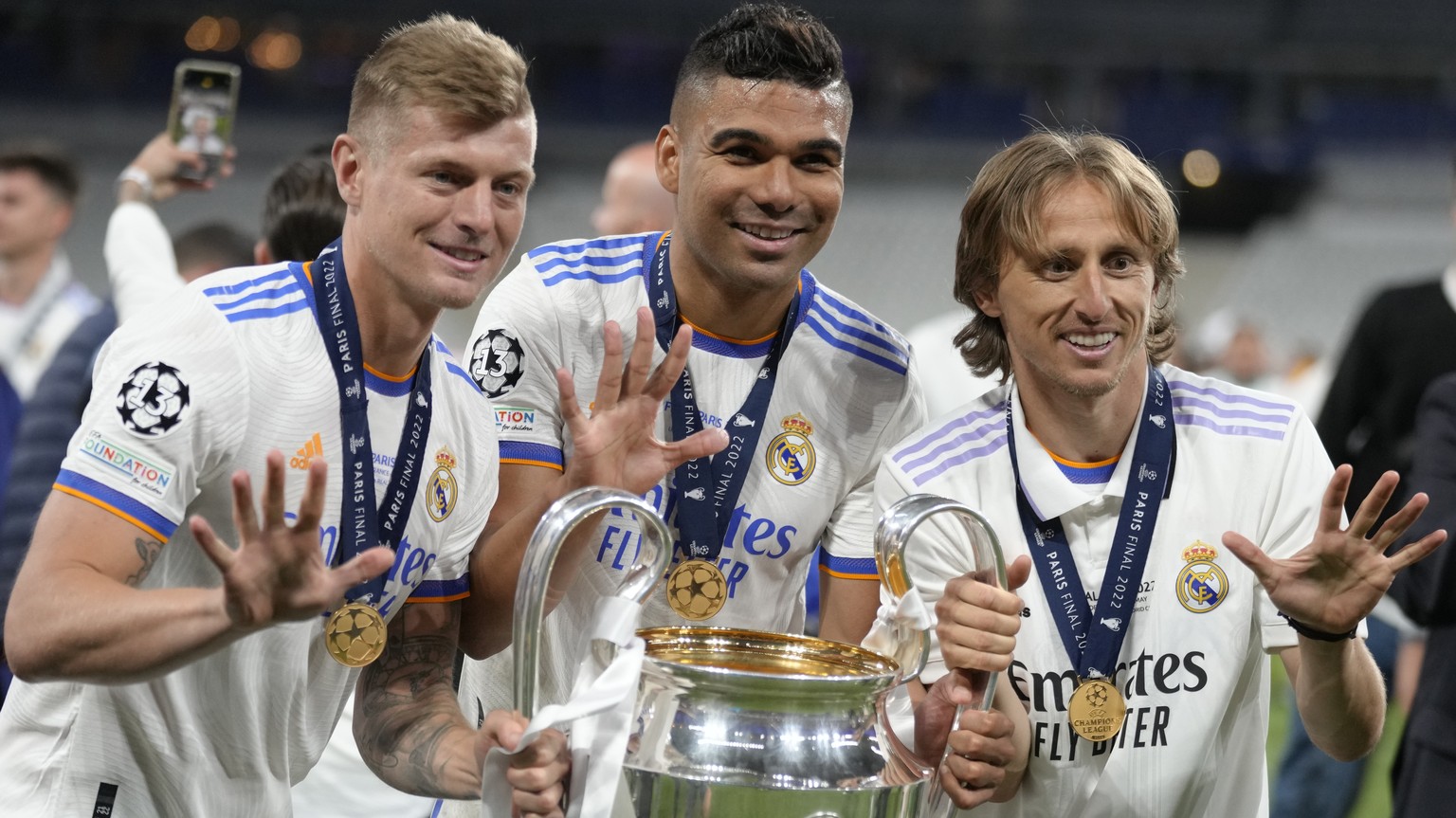 Real Madrid&#039;s Luka Modric, right, Real Madrid&#039;s Casemiro, center, and Real Madrid&#039;s Toni Kroos pose for a photograph with the trophy after winning the Champions League final soccer matc ...