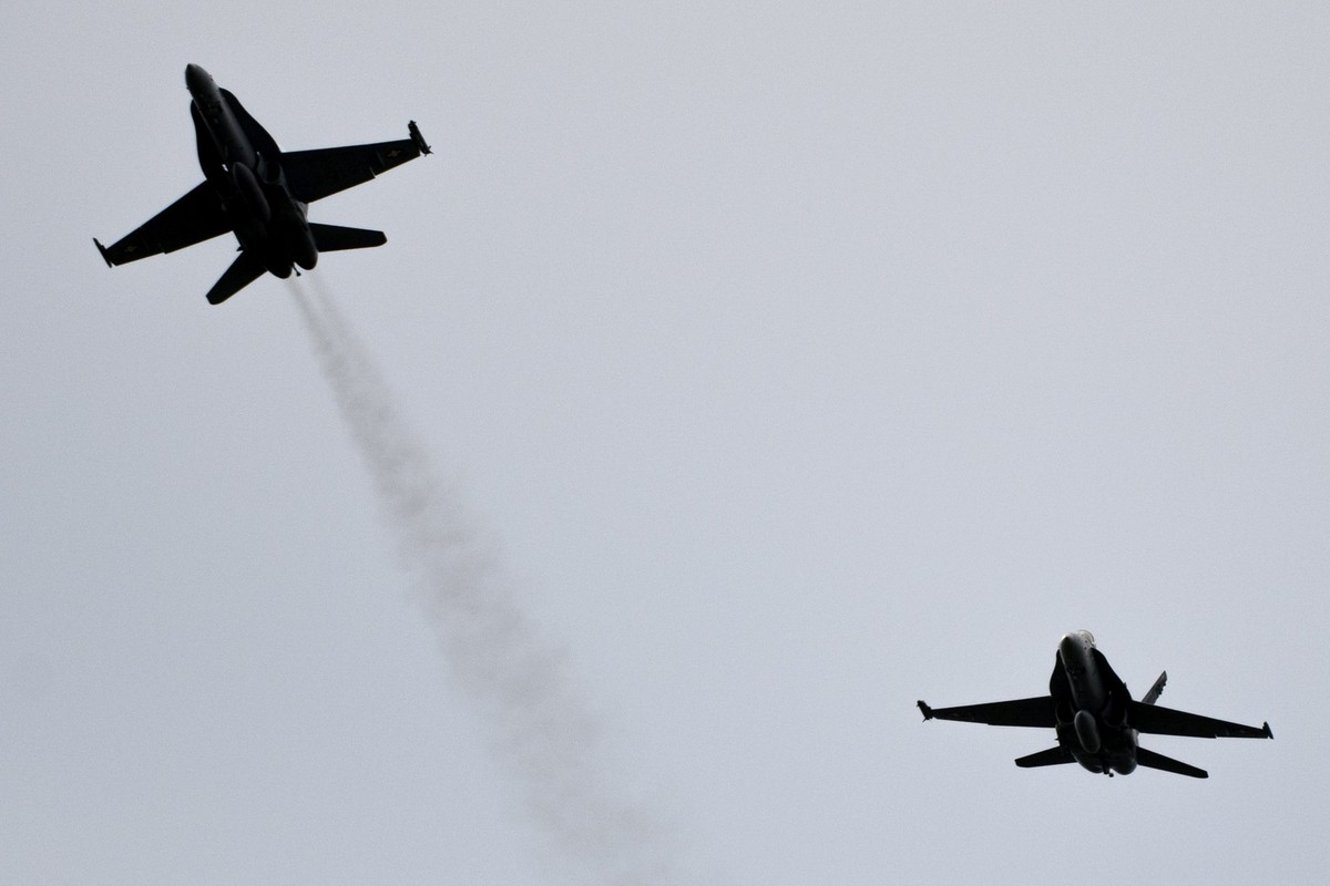 Un avion F/A-18, gauche, quitte la formation de l' armee Suisse volant en formation "Missing man formation" en hommage au pilote du F/A-18 decede le 29 aout dans la region du Susten ce  ...