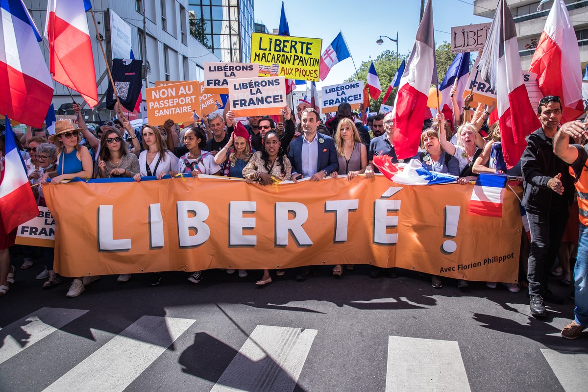 epa09413524 Head of right-wing party 'Les Patriotes' Floriant Philippot (C) leads a march behind a banner reading 'Freedom' during a demonstration against the COVID-19 sanitary pas ...