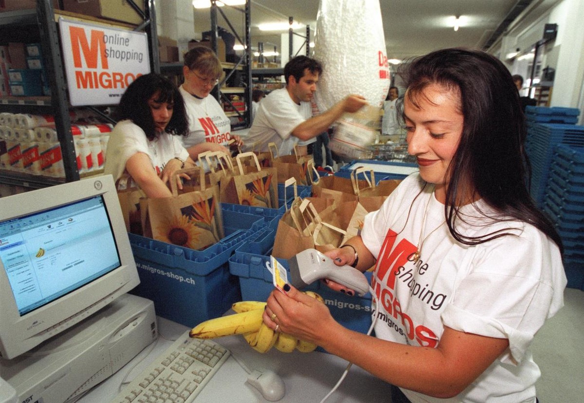 Online Einkaufen bei der Migros im Verteilerzentrum in Bern. Mitarbeiterinnen der Migros scannen an der Kasse den Strichcode der Produkte, welche via Internet bestellt werden und verpacken anschliesse ...
