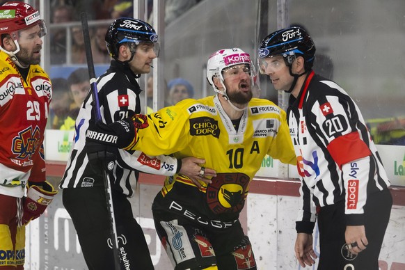 Berns Tristan Scherwey, Mitte, reagiert gegen seine Strafe neben Headschiedsrichter Marc Wiegand, rechts, und Linienrichter Michael Stalder, links, im fuenften Eishockey Playoff Viertelfinalspiel der  ...