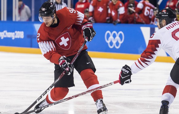 Gaetan Haas of Switzerland, left, in action against Maxim Noreau of Canada, right, during the men ice hockey preliminary round match between Switzerland and Canada in the Kwandong Hockey Center in Gan ...