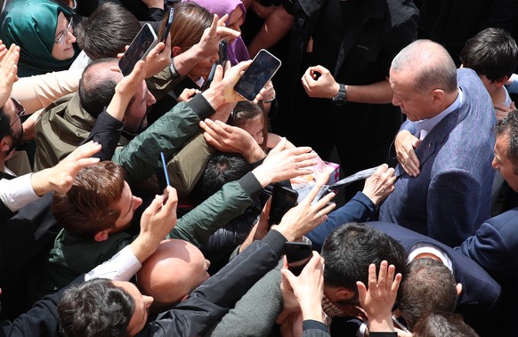 epaselect epa10626776 Turkish President Recep Tayyip Erdogan (R) greets to his supporters after casting his vote at a polling station in Istanbul, Turkey, 14 May 2023, as the country holds simultaneou ...