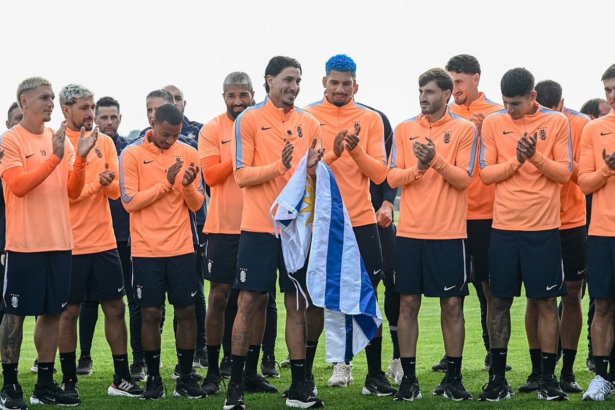 CANELONES, URUGUAY - JUNE 04: The captain of the Uruguayan national football team Jose Maria Gimenez holds a flag of his country alongside his teammates during a farewell ceremony at Uruguay Celeste C ...
