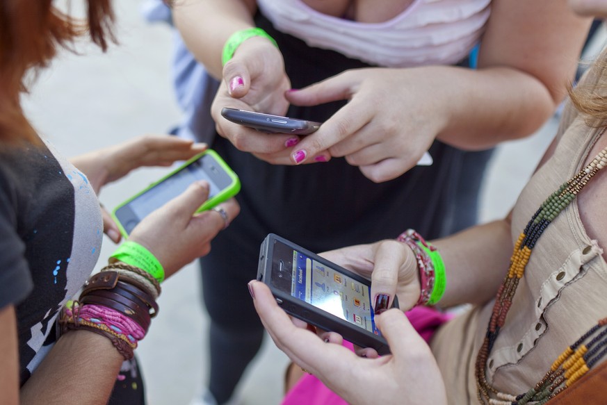 Three women use their smartphones at the &quot;freestyle.ch&quot; festival in Zuerich, Switzerland, pictured on September 25, 2011. Freestyle.ch is a sport event combined with a festival showcasing co ...