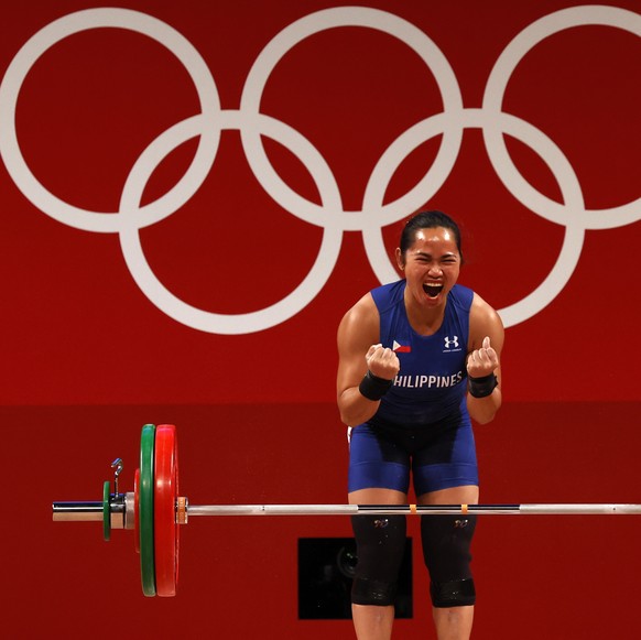 epa09367546 Hidilyn Diaz of the Philippines reacts in the Women&#039;s 55kg Snatch during the Weightlifting events of the Tokyo 2020 Olympic Games at the Tokyo International Forum in Tokyo, Japan, 26  ...