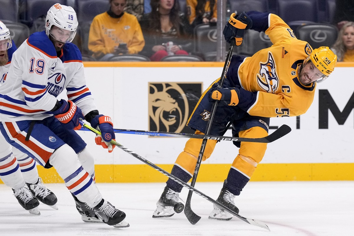 Nashville Predators defenseman Roman Josi (59) shoots the puck past Edmonton Oilers center Adam Henrique (19) during the second period of an NHL hockey game Thursday, Oct. 31, 2024, in Nashville, Tenn ...