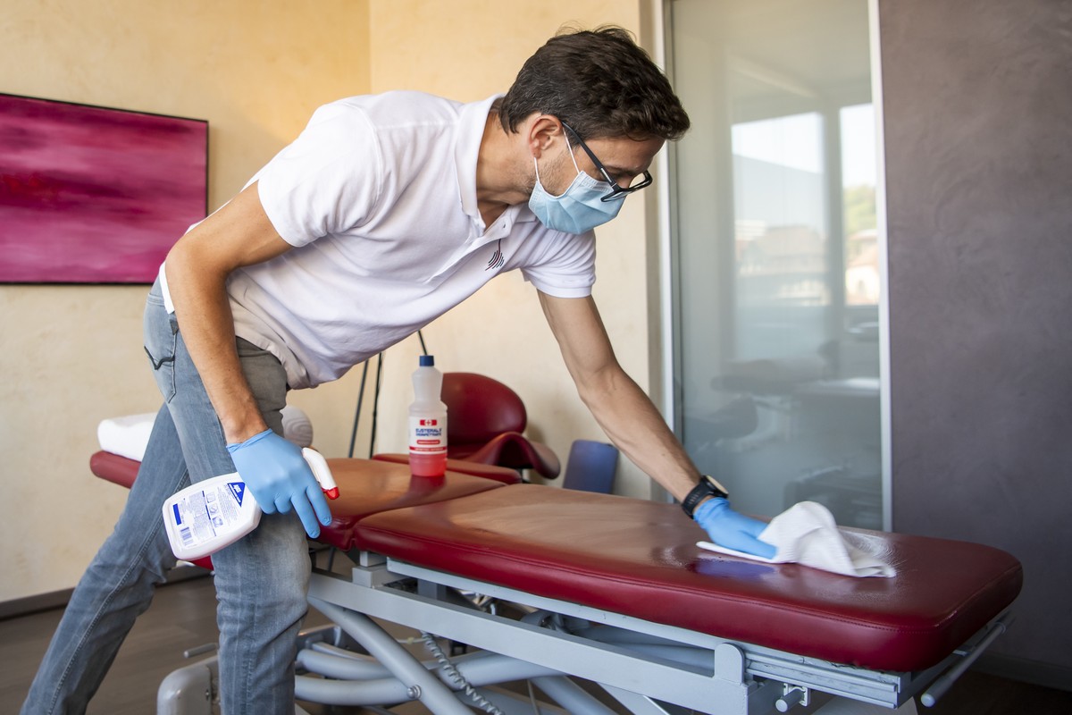 L'osteopathe Boris Hueber, nettoie sa table de massage apres avoir traite un patient en urgence avec de mesures de precautions specifiques dans son cabinet paramedical pendant la crise du Coronav ...