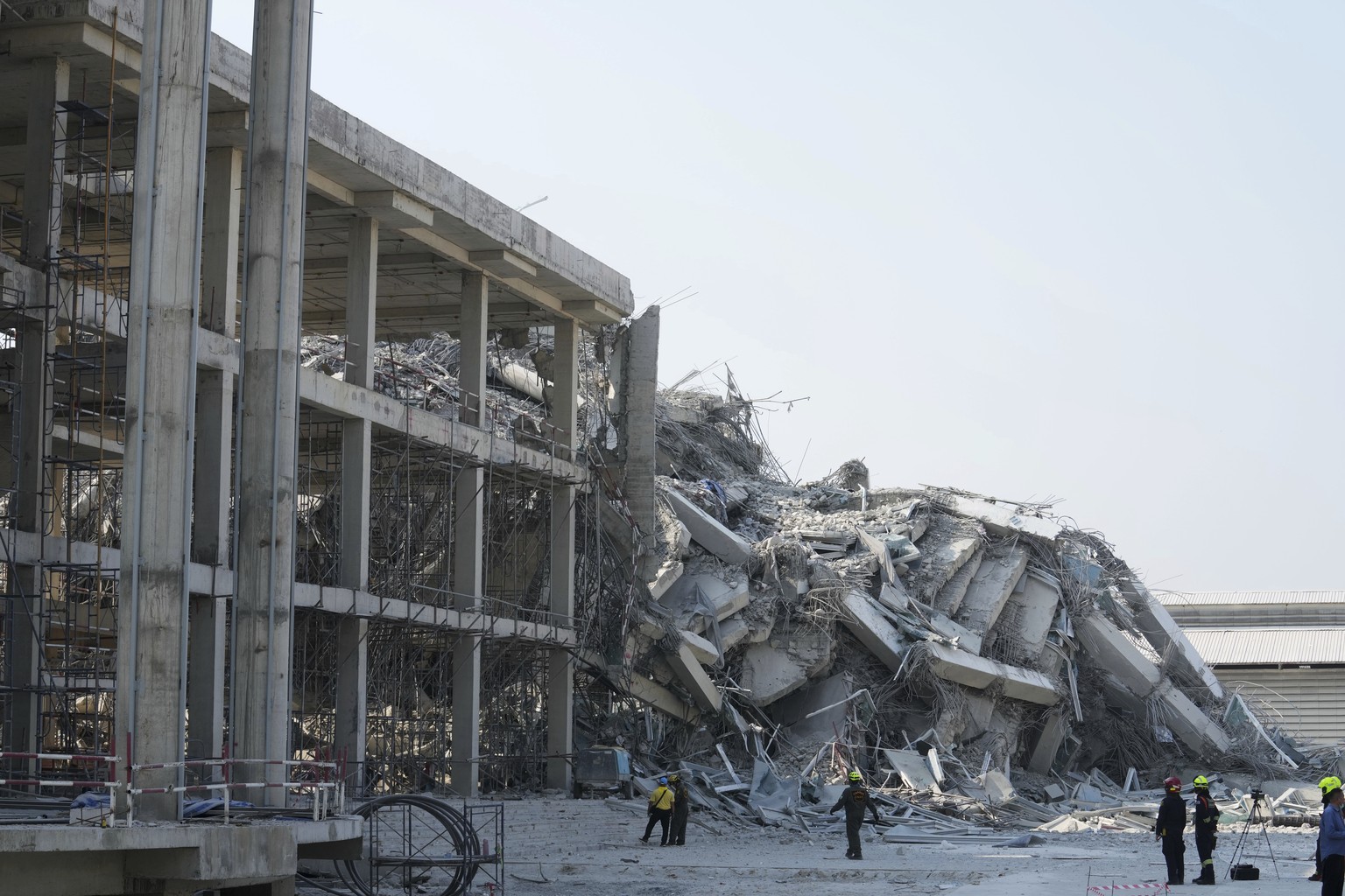 Rescuers walk at the site of a high-rise building under construction that collapsed after a 7.7 magnitude earthquake in Bangkok, Thailand, Friday, March 28, 2025. (AP Photo/Sakchai Lalit)
Thailand Ear ...
