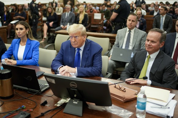 Former President Donald Trump, center, flanked by his defense attorneys, Alina Habba, left, and Chris Kise, waits for the continuation of his civil business fraud trial at New York Supreme Court, Wedn ...