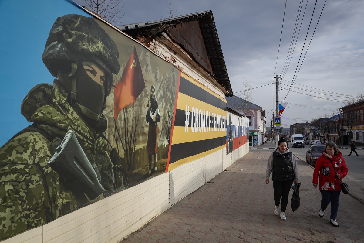 epa10561767 Locals walk next to a banner with a slogan readin: 'We don't leave ours' in the town ofYefremov, Tula region, Russia, 06 April 2023. EPA/MAXIM SHIPENKOV