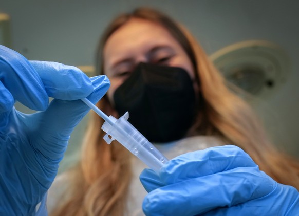 A medical worker holds a rapid test kit in a mobile Corona test van in Frankfurt, Germany, Monday, Nov. 15, 2021. The numbers of Corona infections have been rising again in Germany. (AP Photo/Michael Probst)