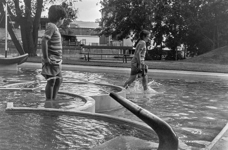 Kinder spielen in den Wasserbecken des Gemeinschaftszentrums Wipkingen, aufgenommen im Juli 1977. (KEYSTONE/Str)