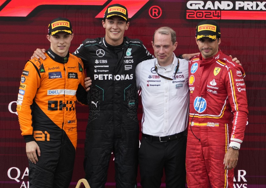Mercedes driver George Russell of Britain, second left, poses with McLaren driver Oscar Piastri of Australia, left, who finished second, and Ferrari driver Carlos Sainz of Spain, right, who finished t ...