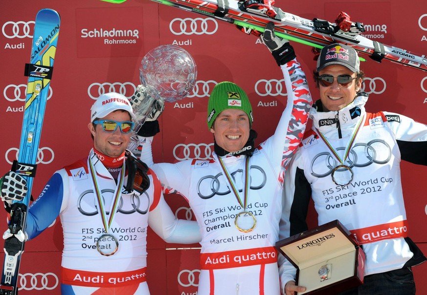 epa03150447 (L-R) second placed Beat Feuz of Switzerland, winner Marcel Hirscher of Austria with the globe, and third placed Aksel Lund Svindal of Norway during the flower ceremony for the Alpine Skii ...