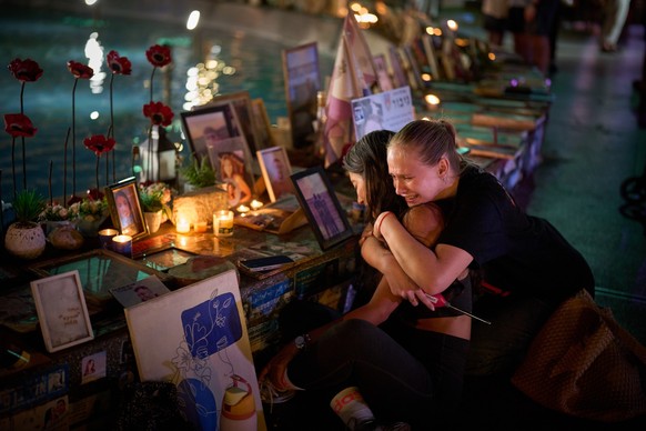 Yuval Miranda and Katya Emelianova cry embracing each other next to the photographs of Israelis who were killed in the Oct. 7, 2023 deadly Hamas attack on Israel, at a memorial marking two years anniv ...